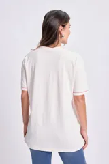 Remera de manga corta, corte oversize y cuello redondo, color crudo con estampado de corazón rojo y rosas.