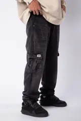Pantalón cargo de jean con lavado ácido en tono gris, corte holgado, bolsillos laterales tipo cargo y bolsillos frontales tipo parche.