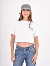 Remera blanca de corte crop, con cuello redondo, mangas cortas y estampa frontal con texto en tipografía cursiva.