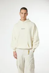 Buzo tipo hoodie color crema, con capucha, bolsillo frontal tipo canguro y logo pequeño bordado en el centro del pecho.