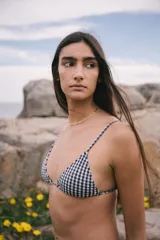 Conjunto de bikini con estampado de cuadrillé azul marino y blanco, compuesto por un corpiño triangular con breteles regulables y espalda para atar, y una bombacha semivedetina con tiras laterales para atar.