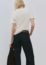 Remera de algodón color blanco, con cuello redondo y mangas cortas. Presenta un estampado frontal con flores en tonos lila y la frase "Self made ready to flourish" en letras negras.