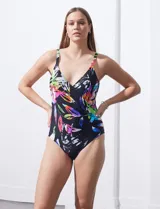 Malla enteriza negra con estampado de hojas de colores, escote en V cruzado y breteles regulables.