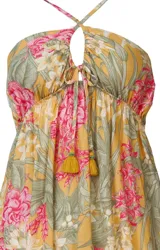 Salida de playa corta con estampado floral, escote halter con cordones ajustables y detalle de borlas en el frente.