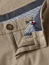 Pantalón chino de corte regular confeccionado en sarga de mezcla de algodón orgánico. Presenta cierre de cremallera con botón y diseño clásico de cinco bolsillos.