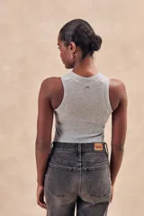 Musculosa de tejido acanalado con acabado brillante, de corte ajustado al cuerpo y cuello redondo alto.