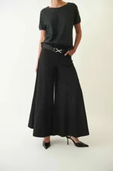 Pantalón tipo palazzo de corte amplio y tiro medio, confeccionado en gabardina rasada. Presenta una silueta fluida y diseño liso en color negro.