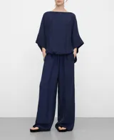 Blusa amplia de color azul marino, con escote barco, manga japonesa y bajo abullonado con elástico interior.