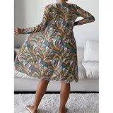 Conjunto de traje de baño de tres piezas con estampado de hojas tropicales en tonos blanco y negro. Incluye un top tipo tankini con cordón ajustable en el centro, un short de tiro alto y una camisa abierta de manga larga tipo salida de baño.