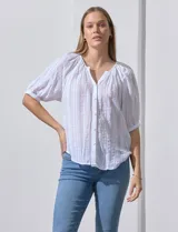 Blusa blanca de algodón marca Zac & Rachel, con cuello a la base, escote en V, abertura central con botones y sisa con aplique calado.