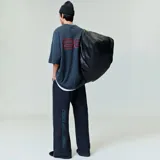 Camiseta negra de algodón con cuello redondo y estampado rojo con el logo "Fear of God Essentials" en el pecho. Corte oversize.