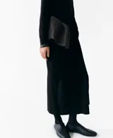Falda midi negra de punto, de corte recto y tiro alto, con detalle de lazo ajustable en la cintura.