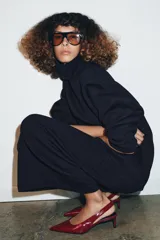 Zapato destalonado de piel color rojo brillante, con punta fina y tacón kitten. Posee una tira trasera elástica para ajuste.