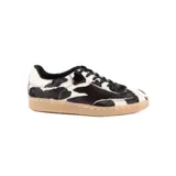 Championes de diseño artesanal con exterior de pelo natural con estampado de manchas tipo vaca en blanco y negro. Presenta cordones negros, interior forrado y suela de goma color caramelo.