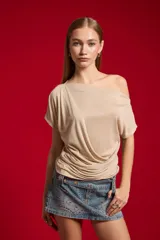 Top de poliéster con hilo Lúrex en color dorado, diseño al cuerpo con escote asimétrico y efecto drapeado.