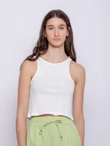 Top blanco de tela texturada, sin mangas y con cuello redondo.