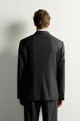 Blazer slim fit de corte estructurado color gris oscuro, confeccionado en tejido con viscosa, con solapas de muesca, bolsillos con solapa en la cadera y cierre frontal de un botón.