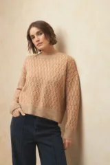 Sweater color beige con diseño de jacquard a dos tonos, de manga larga y cuello a la base.