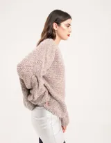 Buzo tejido a mano con lana, color rosa con motas de colores. Diseño oversized, largo entre la cintura y la cadera, con detalle de trenzas en las mangas.