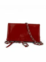 Bandolera roja de cuero charol con cadena metálica plateada.