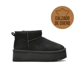 Bota corta tipo ugg de cuero negro con plataforma alta y suela de goma.