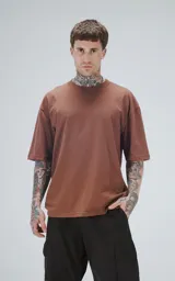 Remera de corte oversize y largo cropped, color marrón mocca, con cuello redondo y mangas cortas con hombros caídos.