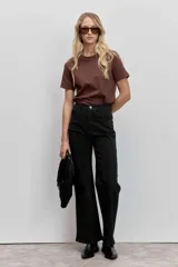 Pantalón de jean corte wide leg color negro, con sutiles detalles de brillo en toda la superficie. Presenta tiro alto, cierre frontal con botón y bolsillos laterales.