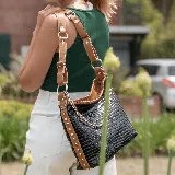 Bolso negro con textura de piel de cocodrilo, con correa de cuero marrón ajustable y correa de cadena plateada removibles.