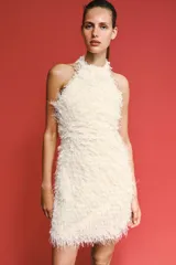 Vestido corto de textura peluda con flecos, diseño de cuello halter y espalda descubierta.