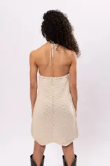 Vestido corto tejido al crochet color crema, con escote halter y espalda descubierta.