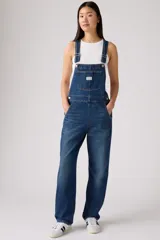 Overall de jean en color azul clásico con lavado desgastado. Presenta un diseño de corte recto y holgado, con bolsillo frontal en el pecho, tirantes ajustables con hebillas metálicas y bolsillos laterales.