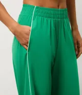 Pantalón deportivo de microfibra color verde, de corte recto y cintura elastizada, con línea lateral en contraste.