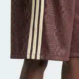 Shorts capri Adidas de color marrón con diseño texturizado en relieve y las icónicas tres franjas blancas en los laterales. Cuenta con cintura elástica y el logo de la marca bordado en la pierna.