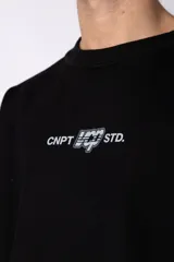 Buzo de cuello redondo confeccionado en tejido rústico con bordes al corte y costuras expuestas. Presenta un diseño boxy con estampado frontal y es reversible, permitiendo su uso por ambos lados.