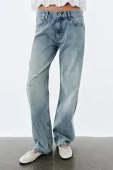 Jeans de tiro bajo y corte recto, con diseño de cinco bolsillos, trabillas en la cintura y efecto lavado con detalles de rotos en el frente.