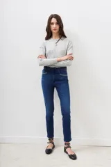 Jean de tiro medio y corte slim, confeccionado en denim azul con lavado localizado y apliques de hotfix en los bolsillos delanteros.