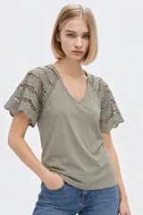 Remera color verde militar con cuello en V y mangas cortas confeccionadas en tejido broderie con detalles calados.