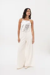 Jean de corte wide leg en color blanco, confeccionado en algodón con textura de pequeños cortes lineales en toda la superficie. Presenta tiro medio, cierre frontal con botón y bolsillos laterales.