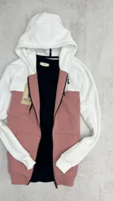 Campera con capucha blanca y cuerpo rosa viejo, con cierre frontal y bolsillos laterales. Logo bordado en el pecho.