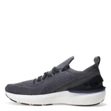 Championes de running Under Armour Shift para hombre, color gris oscuro con malla transpirable, cordones negros y detalles en amarillo neón. Presentan una entresuela gruesa de espuma blanca para amortiguación y un estabilizador de talón en azul marino.
