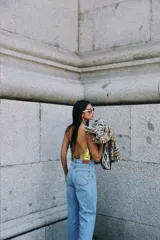 Pantalón vaquero blanco de tiro alto, corte recto con tajo lateral y terminación en cuero.