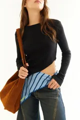 Top de manga larga color blanco, confeccionado en tejido de punto acanalado con diseño irregular y aberturas para los pulgares en los puños.