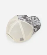 Gorra estilo trucker con panel frontal estructurado en sarga con estampado camuflado y laterales de malla transpirable. Presenta visera curva y ajuste posterior regulable.