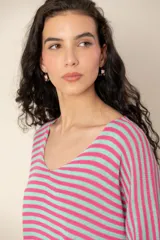 Sweater de tejido de punto a rayas horizontales en tonos beige y blanco, con escote en V y mangas cortas holgadas.