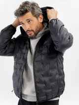 Campera puffer negra con diseño capitoneado, cierre frontal completo y capucha integrada.