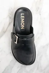 Zueco negro de cuero con hebilla metálica plateada ajustable y suela track.