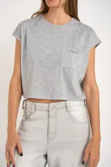 Remera gris de algodón con poliéster, corte crop, mangas cortas y bolsillo en el pecho.
