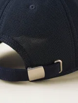 Gorra de béisbol azul marino con visera curva y detalle de costuras en contraste.