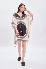 Vestido corto sin mangas color crudo, con escote en V y ajuste en el busto mediante lazos. Presenta un estampado geométrico en tonos marrones y negros.