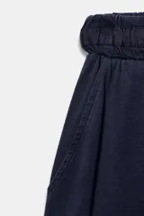 Pantalón balloon de tiro alto confeccionado en algodón, con cintura elástica ajustable mediante cordones tono sobre tono y bolsillos en el delantero.